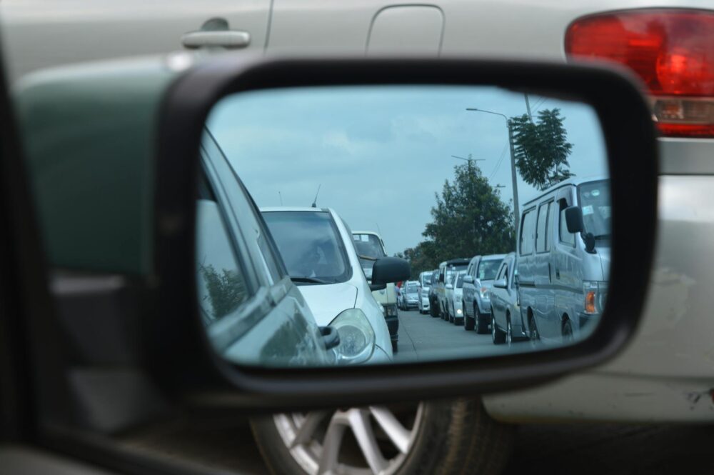 car side mirror showing heavy traffic Zo blijf je mobiel in de stad