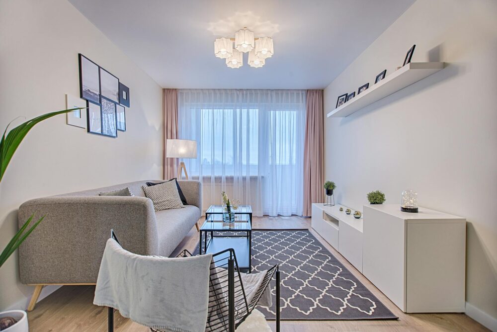 gray fabric padded sofa and glass top coffee table inside living room Raamdecoratie doet meer dan je denkt!